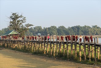 Locals and monks on a teak bridge
