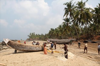 Group of fishermen sorting their nets on the beach