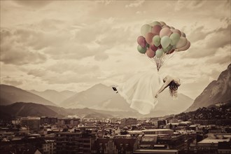 Bride floating on balloons over Innsbruck