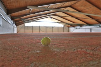 Damaged tennis ball standing in a tennis hall in need of redevelopment