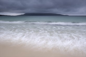 Mount Ceapabhal veiled by dark rain clouds on the horizon
