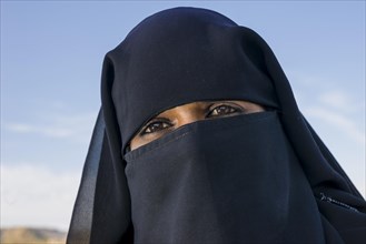 A portrait of a young veiled Muslim woman visiting the Bibi Ka Maqbara