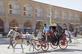 Iranians riding in a horse-drawn carriage