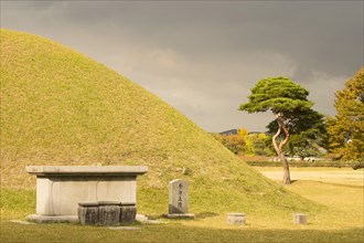 Tumulus grave in front of a mystically darkened sky