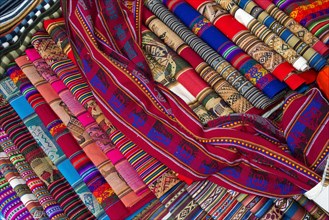 Hand-woven fabrics with the traditional patterns of the Quechua Indians are displayed for sale