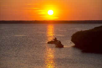Anglers with boats at sunset on the Bodstedter Bodden lagoon