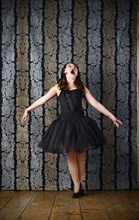 Girl wearing a black ballet dress screaming
