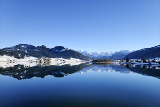 Snow-capped mountains reflected in the Sihl reservoir