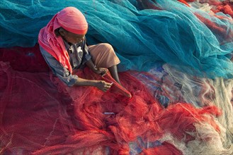Fisherman repairing fishing nets