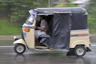 Three-wheeler in heavy rain