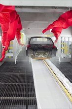 Robots paint a car body in the paint shop at Chrysler's Sterling Heights Assembly Plant