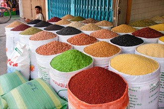 Market vendor offering various sorts of beans