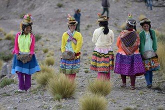 Young women carrying heavy stones to secure the shores of an artificial lake for irrigation