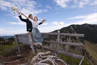 Wedding couple on a mountain throwing the bridal bouquet