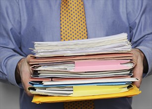 Businessman carrying a stack of paperwork