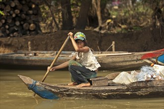 Girl paddling a traditional boat on the Sangker river in Battambang