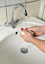 Washing hands with German curd soap in a washbasin