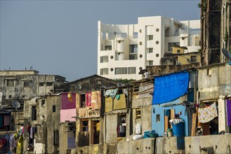 Typical homes of poor working class Indians in front of a modern residential building