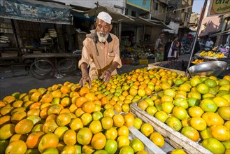 A salesman is offering oranges at the market
