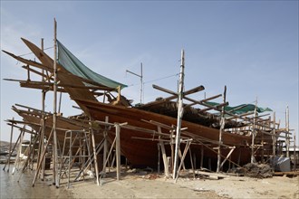 Shipyard with an old dhow-ship being repaired