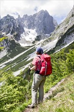 Female hiker looking towards the Wilder Kaiser Mountains from the Wilder-Kaiser-Steig hiking trail