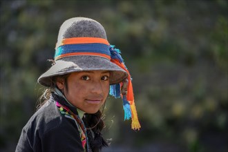 Indio girl with hat with colorful ribbons smiles