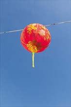 Red Chinese New Year lantern against blue sky