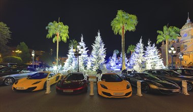 Four McLaren sports car in front of Christmas decoration with white fir trees on the square in front of the Casino de Monte-Carlo