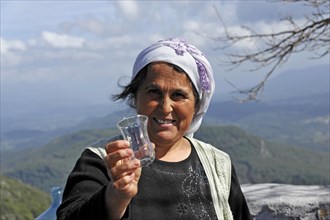 Turkish woman passing a glass in Akyaka