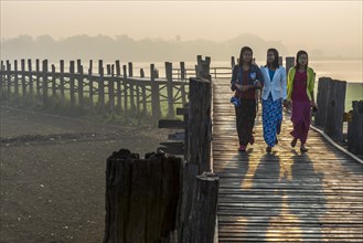 Girls with tanaka on their faces on a teak bridge