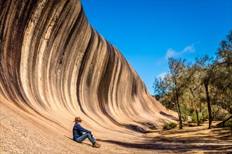 Man resting at the bottom of Wave Rock