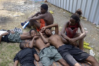 A group of street children resting on blankets on a grassy area in the centre of Rio de Janeiro