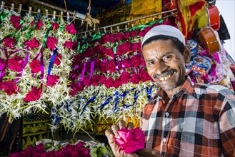 A Muslim salesman is selling flowers