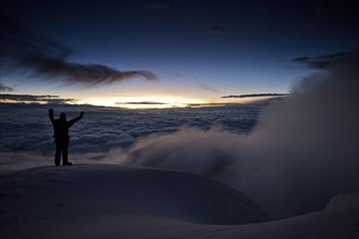 Mountain climber on the summit of Cotopaxi Volcano at sunrise
