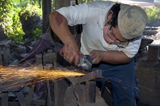 Metal worker grinding in a metalworking shop