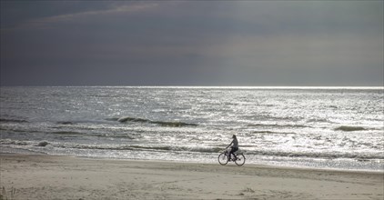 Cyclist on the sandy beach on the Baltic Sea
