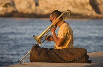 Musician playing the trombone at the Malecon esplanade