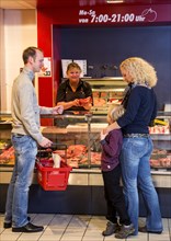 Family shopping at the meat counter in a supermarket