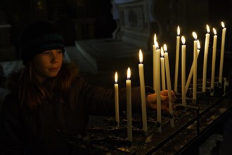 Girl lighting a votive candle