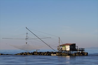 Fisherman's house with a net over the sea in Marina di Pisa
