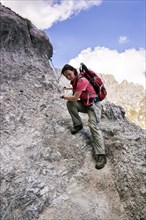 Female hiker climbing the fixed cable route of Jubilaeumssteig