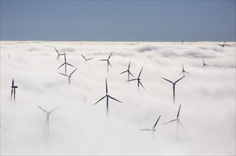 Wind turbines covered by low clouds
