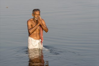 Pilgrim taking a bath praying in the holy Yamuna river