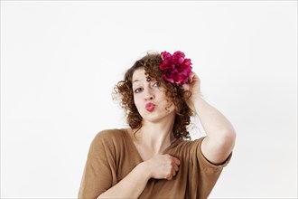 Young woman with red lips and a flower in her hair
