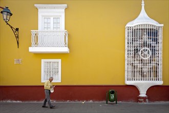 Old man walking in front of Casa de la Emancipacion