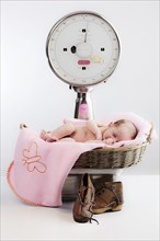 Baby lying in a basket on a scale