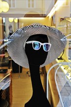 Mannequin wearing a hat and sunglasses