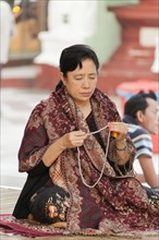 Buddhist woman in morning prayer at the Shwedagon Pagoda