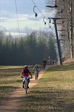 Mountain bikers are pulled by a ski lift