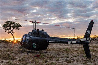 Helicopter in the African savannah at sunset
